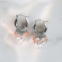Créoles glamour argentées avec cristaux Boucles d'oreilles argentées avec cristaux roses et clairs sur fond de marbre