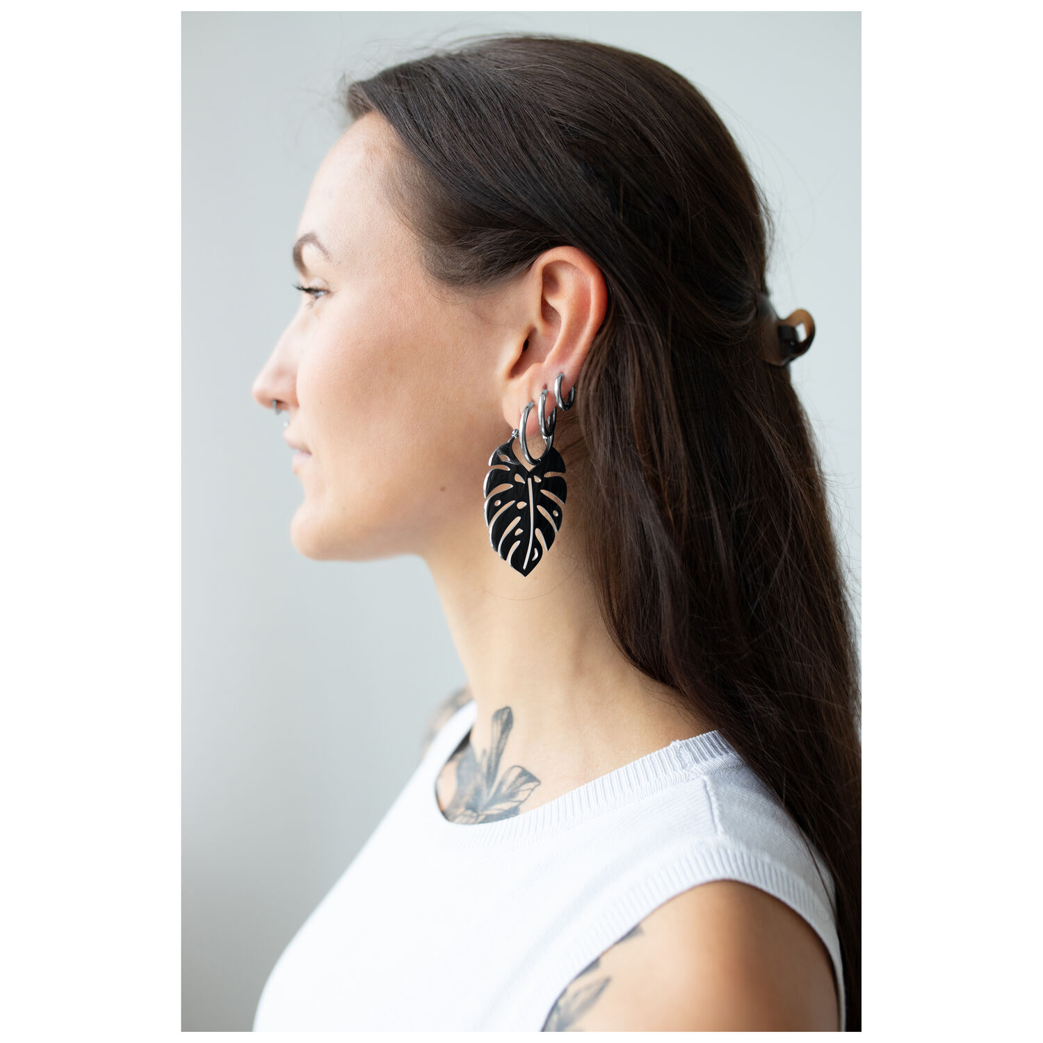 Créoles Feuille de Monstera en Noir et Argent Femme avec boucles d'oreilles Monstera en noir et argent sur fond clair
