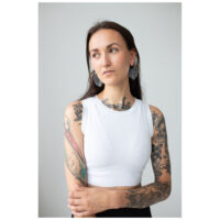 Monstera Leaf Hoops avec femme en studio Femme aux bras tatoués portant des boucles d'oreilles Monstera Leaf Hoops, top blanc