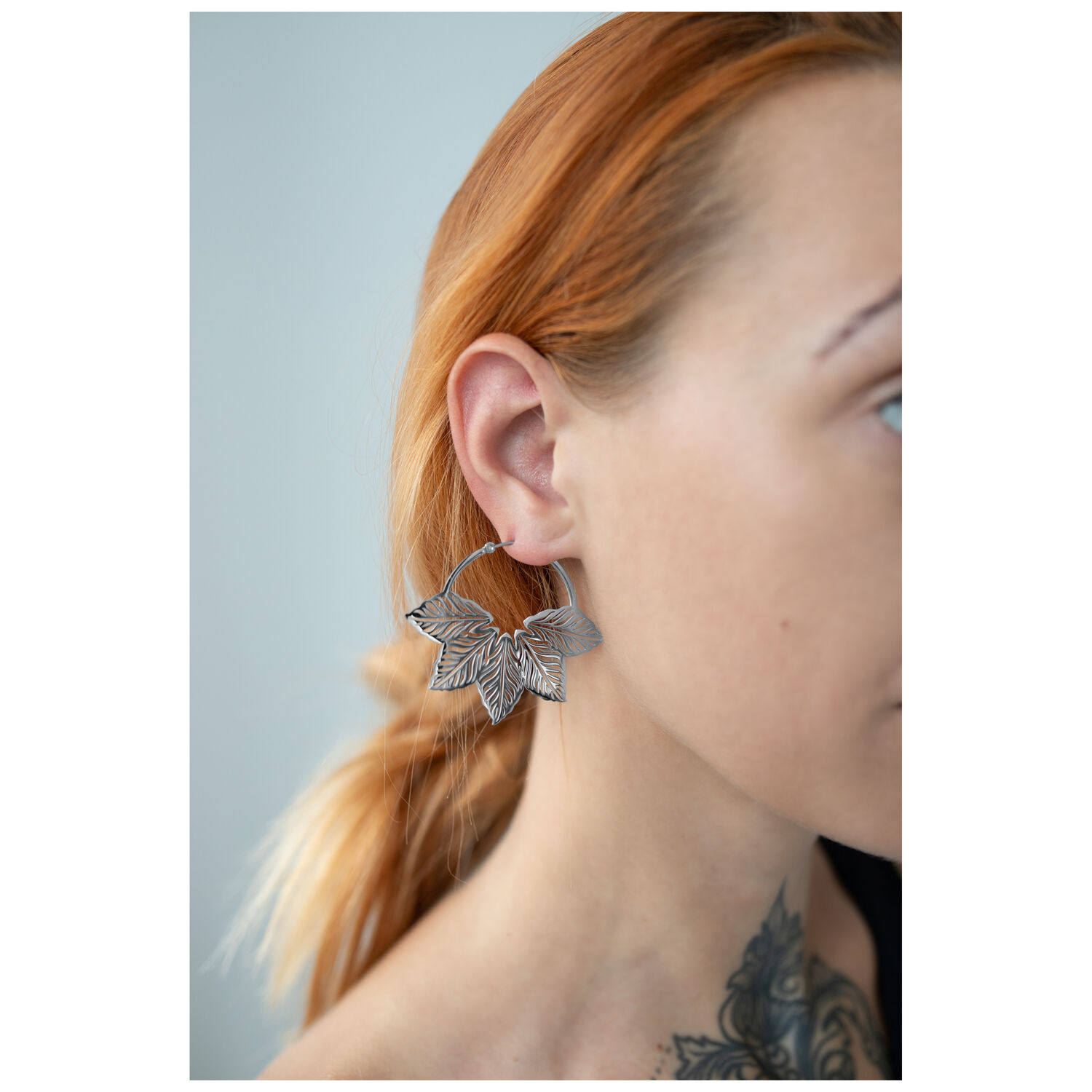Boucles d'oreilles Abey Hoops en forme de feuille Boucles d'oreilles en argent en forme de feuille sur l'oreille d'une personne aux cheveux rouges