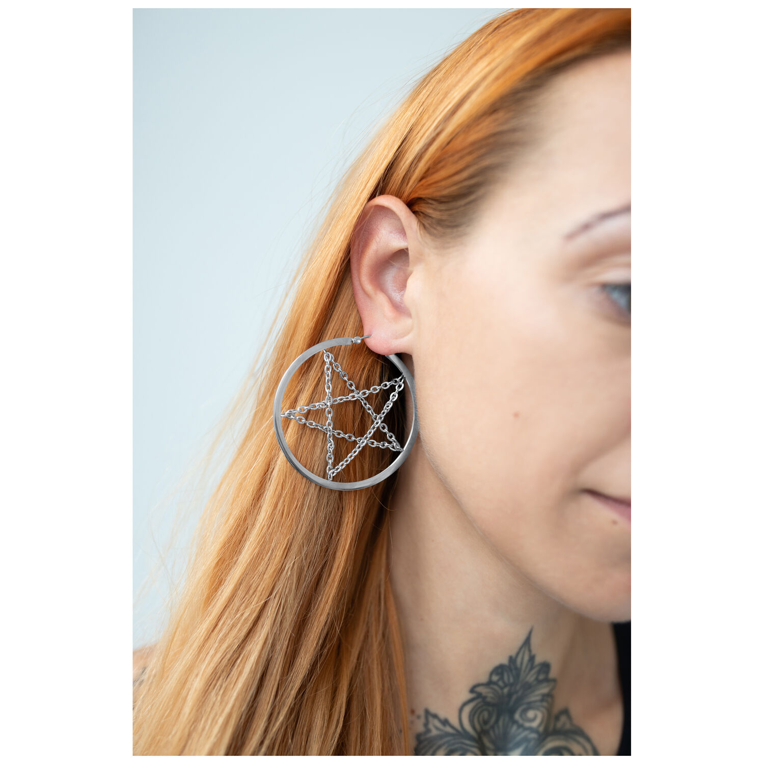 Boucles d'oreilles pentagramme argentées avec chaîne, portées à l'oreille, fond clair