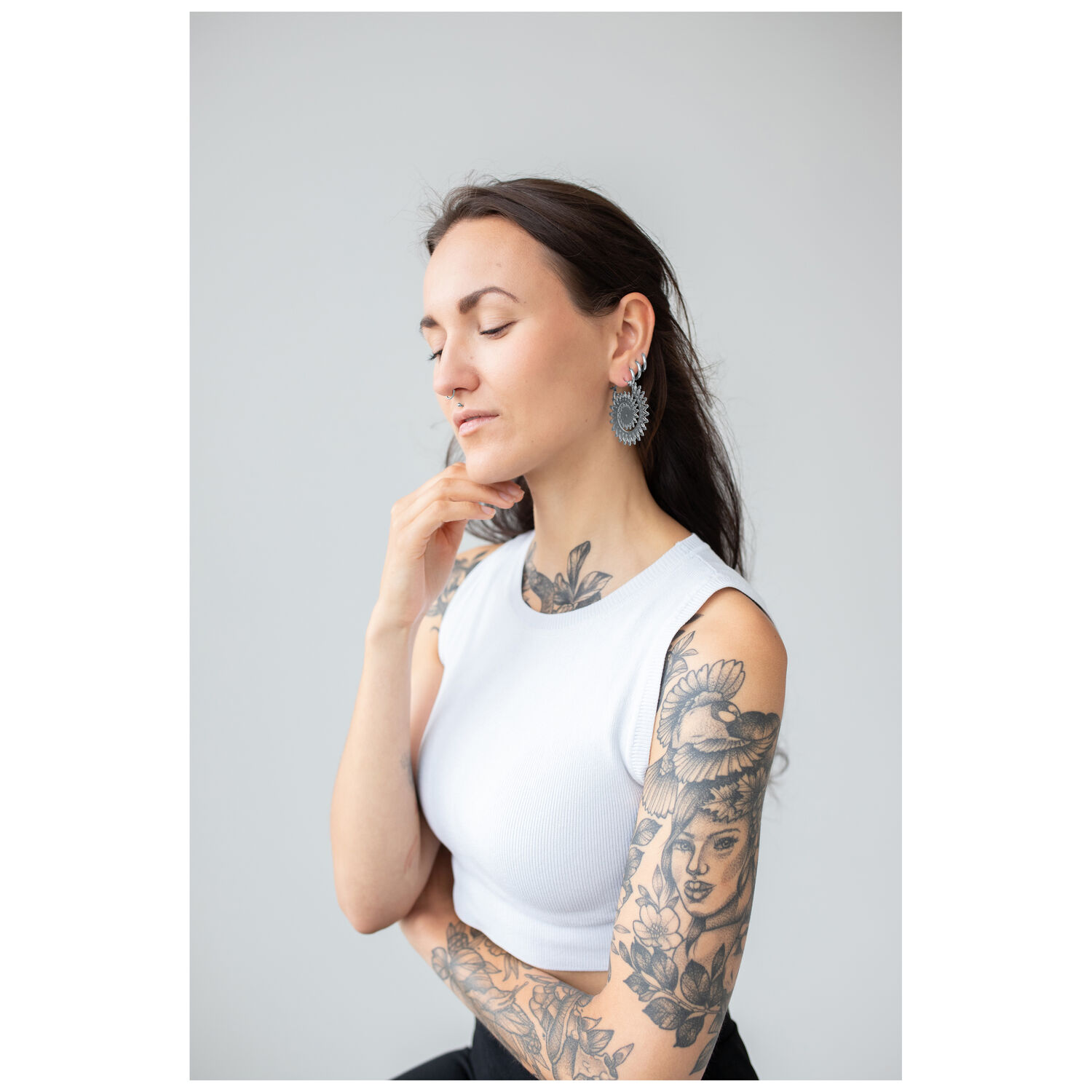 Floral Nautilus Hoops sur modèle Femme avec bras tatoué portant des Floral Nautilus Hoops en argent sur fond gris