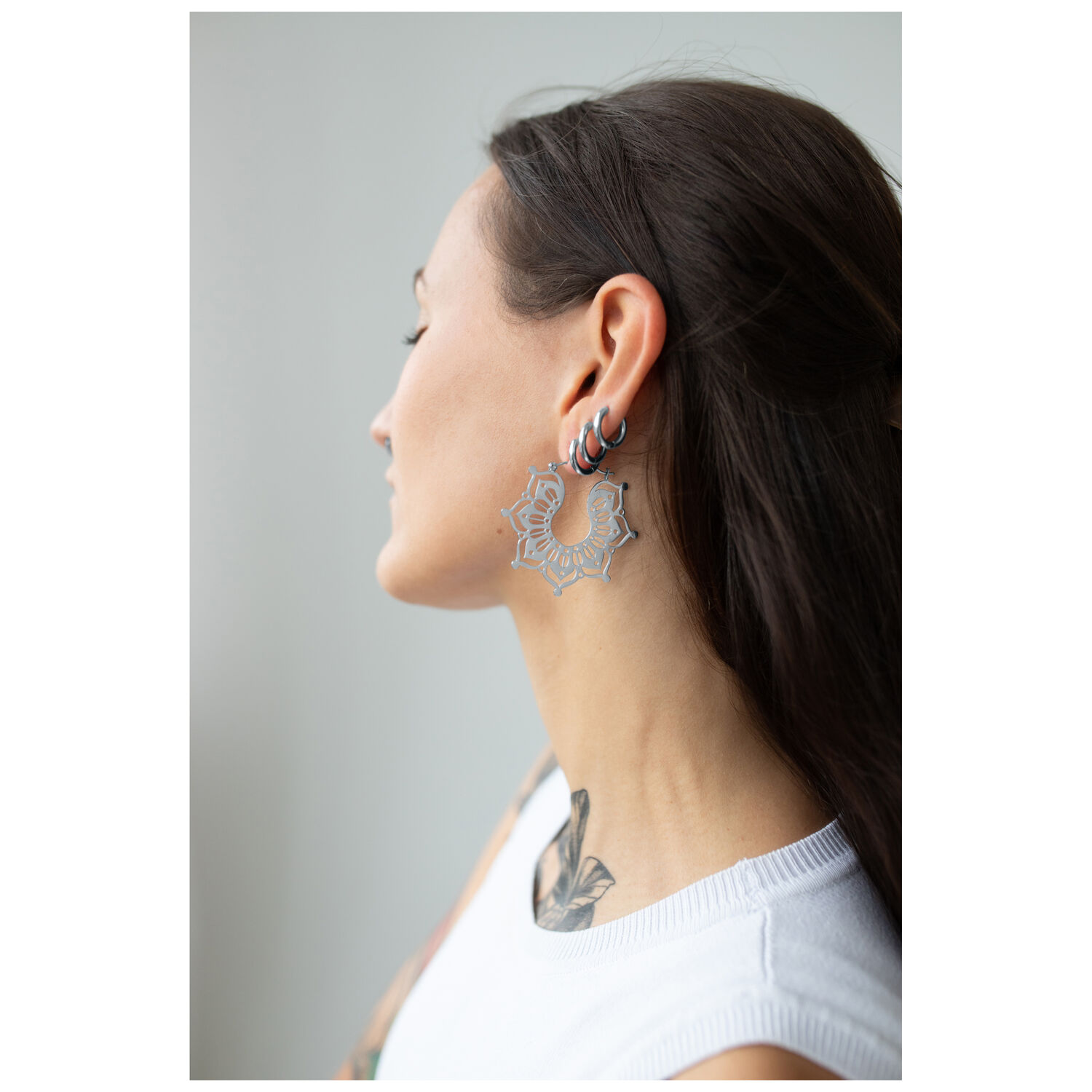 Boucles d'oreilles Magnolia Hoops argentées à l'oreille Femme aux longs cheveux portant des boucles d'oreilles Magnolia Hoops argentées
