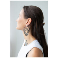 Thunderflash Eye Hoops portés en noir Femme aux longs cheveux portant de grandes boucles d'oreilles Thunderflash Eye Hoops noires de côté