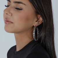 Boucles d'oreilles Curbchain Hoops en argent Boucles d'oreilles Curbchain Hoops en argent sur une femme aux cheveux foncés devant un fond neutre