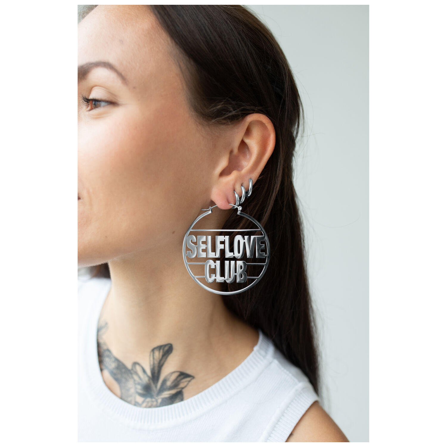 Boucles d'oreilles Selflove Club Hoops argentées Boucles d'oreilles Selflove Club Hoops argentées portées à l'oreille, gros plan