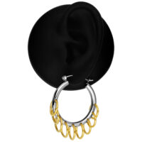 Créoles argentées avec pendentifs dorés Créole argentée avec plusieurs anneaux dorés sur fond noir