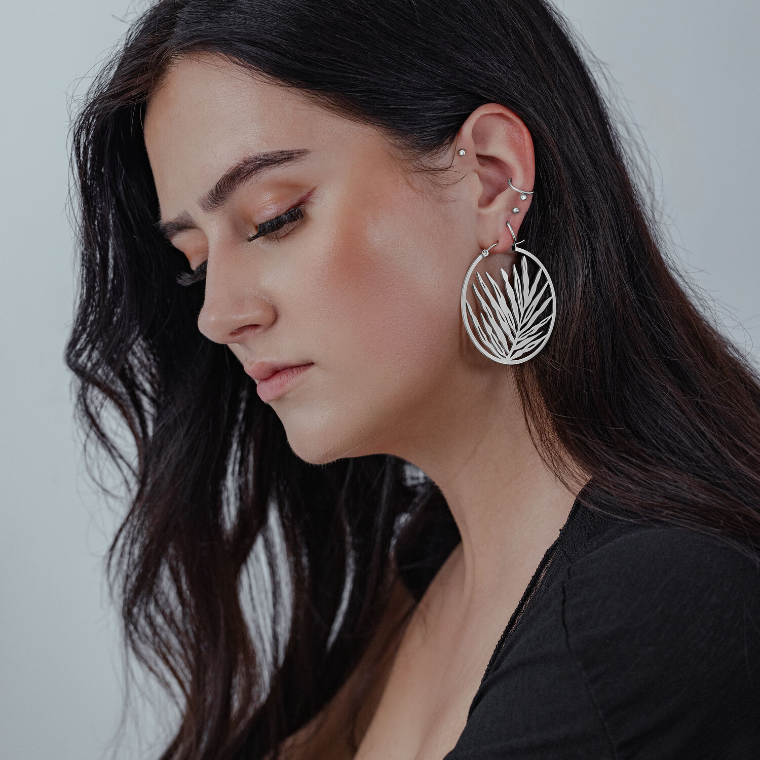 Boucles d'oreilles Noble Leaf Hoops en argent Boucles d'oreilles Noble Leaf Hoops en argent portées par une femme aux cheveux longs et foncés