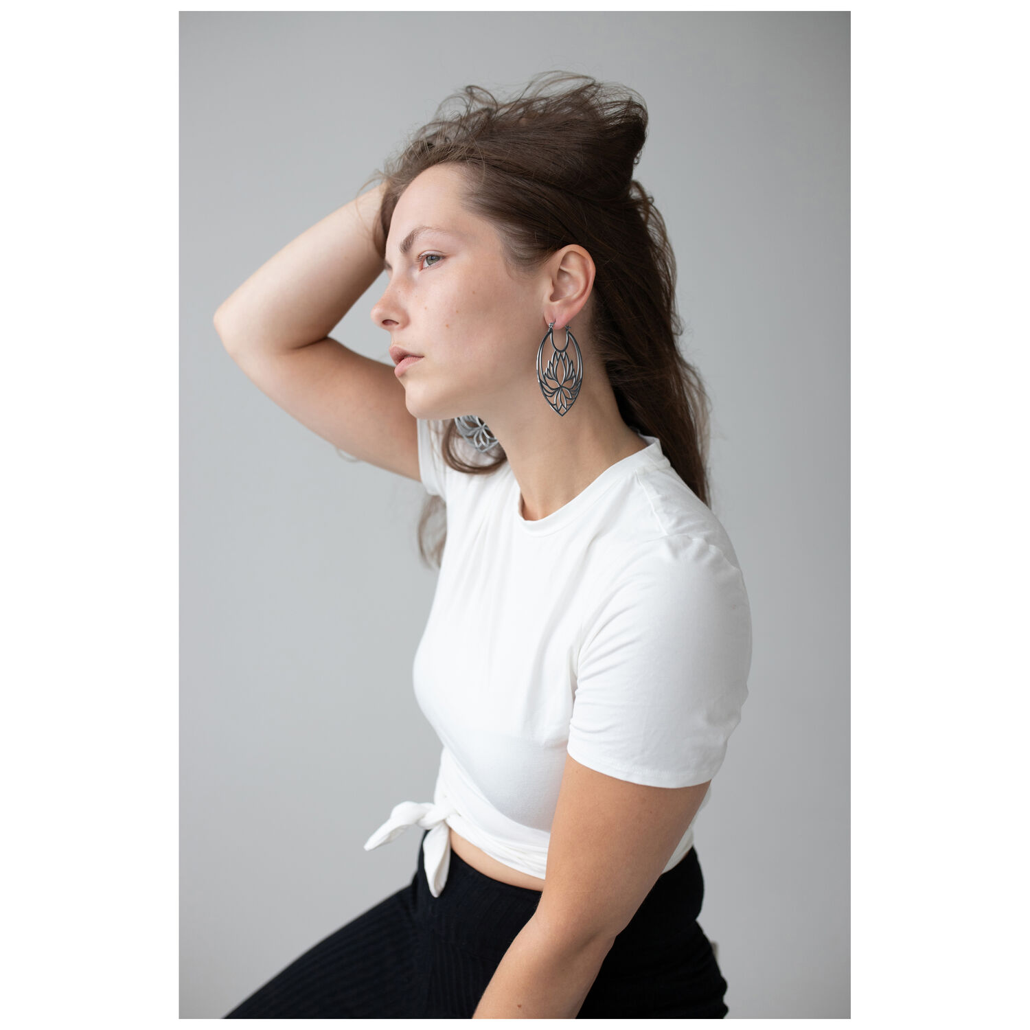 Boucles d'oreilles Lotus Hoops en noir et argent Femme avec des boucles d'oreilles Lotus Hoops en acier inoxydable noir et argent sur fond gris