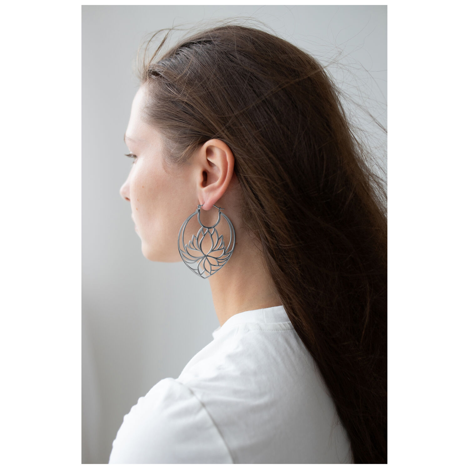 Créoles Lotus au design élégant Boucles d'oreilles Lotus en argent sur une femme aux longs cheveux et chemise blanche