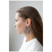 Boucles d'oreilles Lotus Hoops au design audacieux Femme aux longs cheveux portant de grandes boucles d'oreilles Lotus Hoops noires
