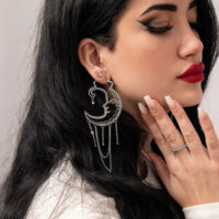 Créoles Sun Moon en argent stylées Femme avec créoles Sun Moon en argent, profil latéral, fond uni