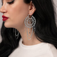 Boucles d'oreilles Sun Moon en acier inoxydable Boucles d'oreilles argentées avec design soleil-lune sur une femme aux cheveux foncés