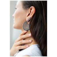 Boucles d'oreilles Cathedral Hoops en noir et argent Femme portant de grandes boucles d'oreilles rondes en noir et argent avec un design délicat.