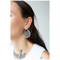 Boucles d'oreilles Cathedral élégantes en argent Boucles d'oreilles Cathedral en argent portées par une femme, fond blanc
