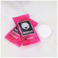 Deux pastilles dextrose citron Wildcat roses sur fond de marbre