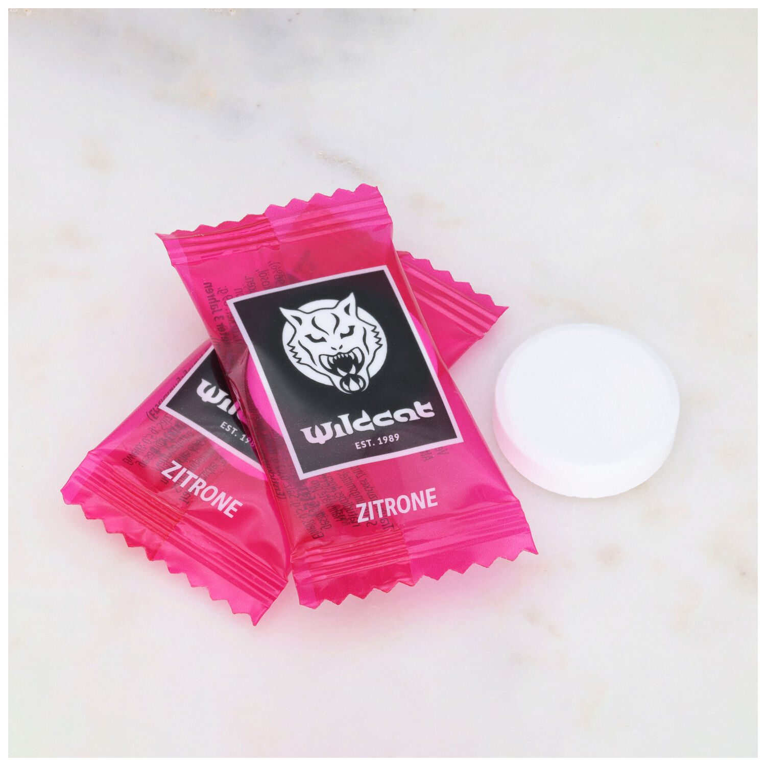 Deux pastilles dextrose citron Wildcat roses sur fond de marbre