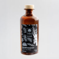 Bouteille en verre brun avec étiquette noire, motifs botaniques, fond gris