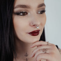 Clicker de Septum Chunky Opale en Argent Femme aux cheveux noirs portant un clicker de septum en argent avec opale sur fond clair