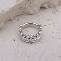 Triple Bubble Clicker en argent avec des cristaux blancs sur une pierre beige