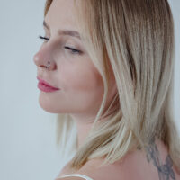 Femme aux cheveux blonds portant un clicker de nez à cristaux double rangée noir sur fond neutre