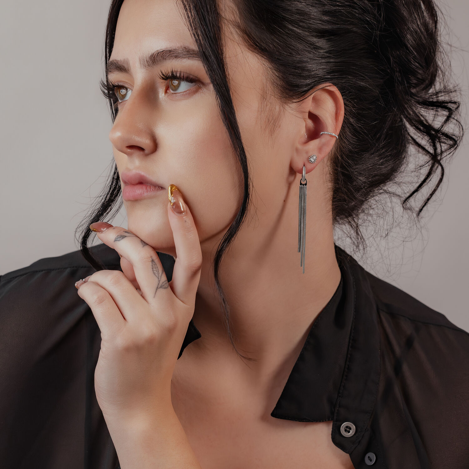 Femme avec un élégant piercing Pearl Clicker en argent à l'oreille, cheveux noirs