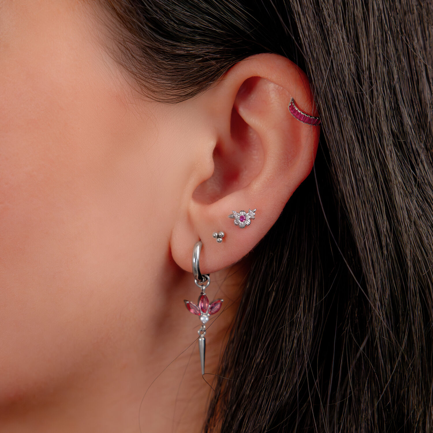 Clicker argenté avec cristaux rouges, 8 mm Oreille avec plusieurs piercings, y compris un clicker argenté avec cristaux rouges.