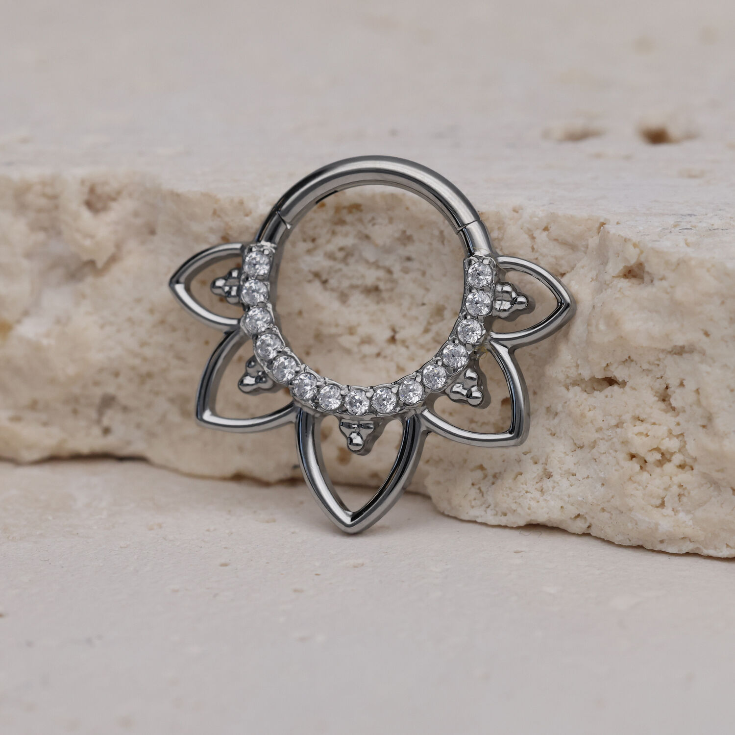 Clicker de septum argenté avec cristaux clairs sur pierre claire