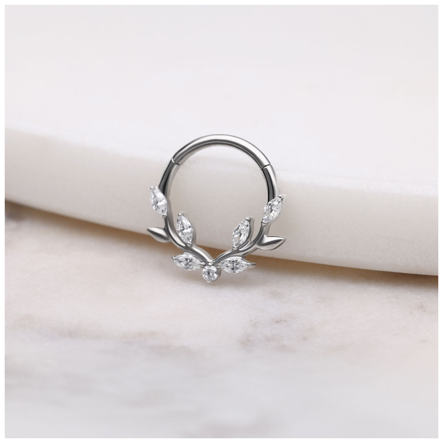 Clicker de septum argenté avec feuilles de cristal sur fond blanc