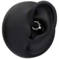 Clicker septum argenté avec cristaux en forme de cœur sur une oreille modèle noire