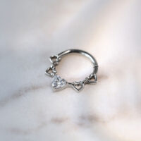 Clicker de septum en titane argenté avec design de cœur et cristaux sur fond marbré