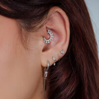 Clicker Halo Cristal pour Septum dans l'Oreille Oreille avec plusieurs piercings, y compris un Clicker Halo Cristal argenté dans le cartilage.