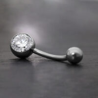 Élégant piercing de nombril avec cristal Banane noire en titane avec cristal clair sur fond gris