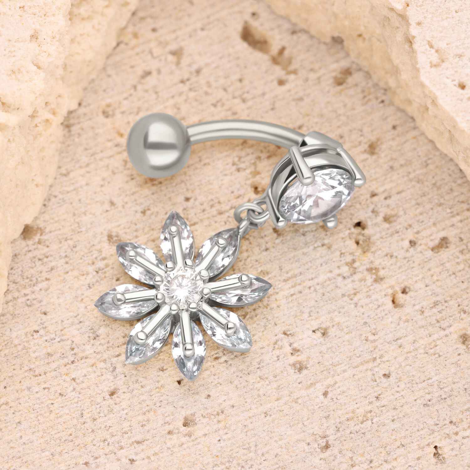 Piercing de nombril fleur argentée avec cristal Piercing bananabell argenté avec pendentif en cristal en forme de fleur sur fond sable