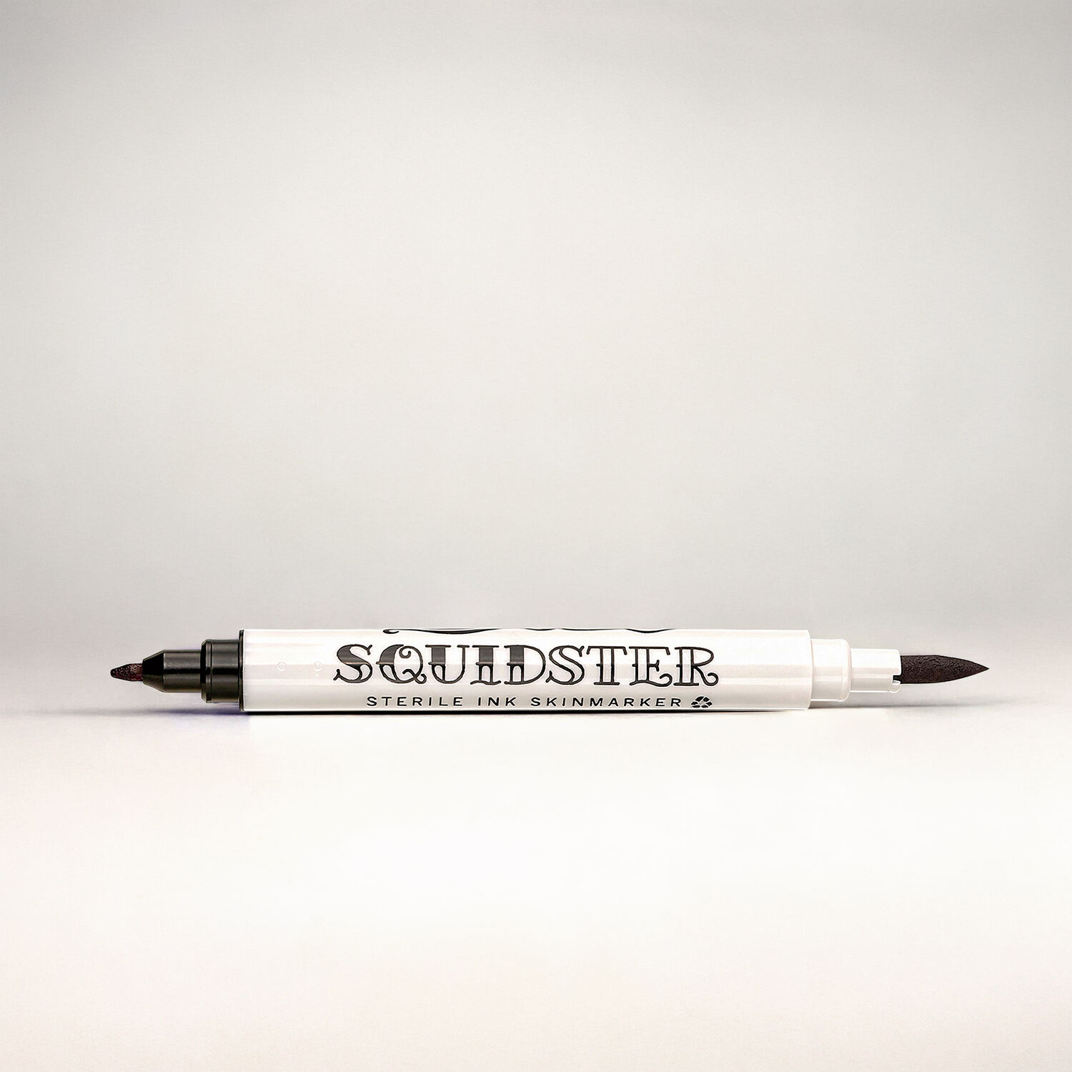 Marqueur de tatouage Squidster noir Marqueur de tatouage blanc avec deux pointes noires sur fond gris