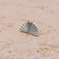 Embout demi-cercle argenté rainuré Embout demi-cercle argenté rainuré sur surface sable