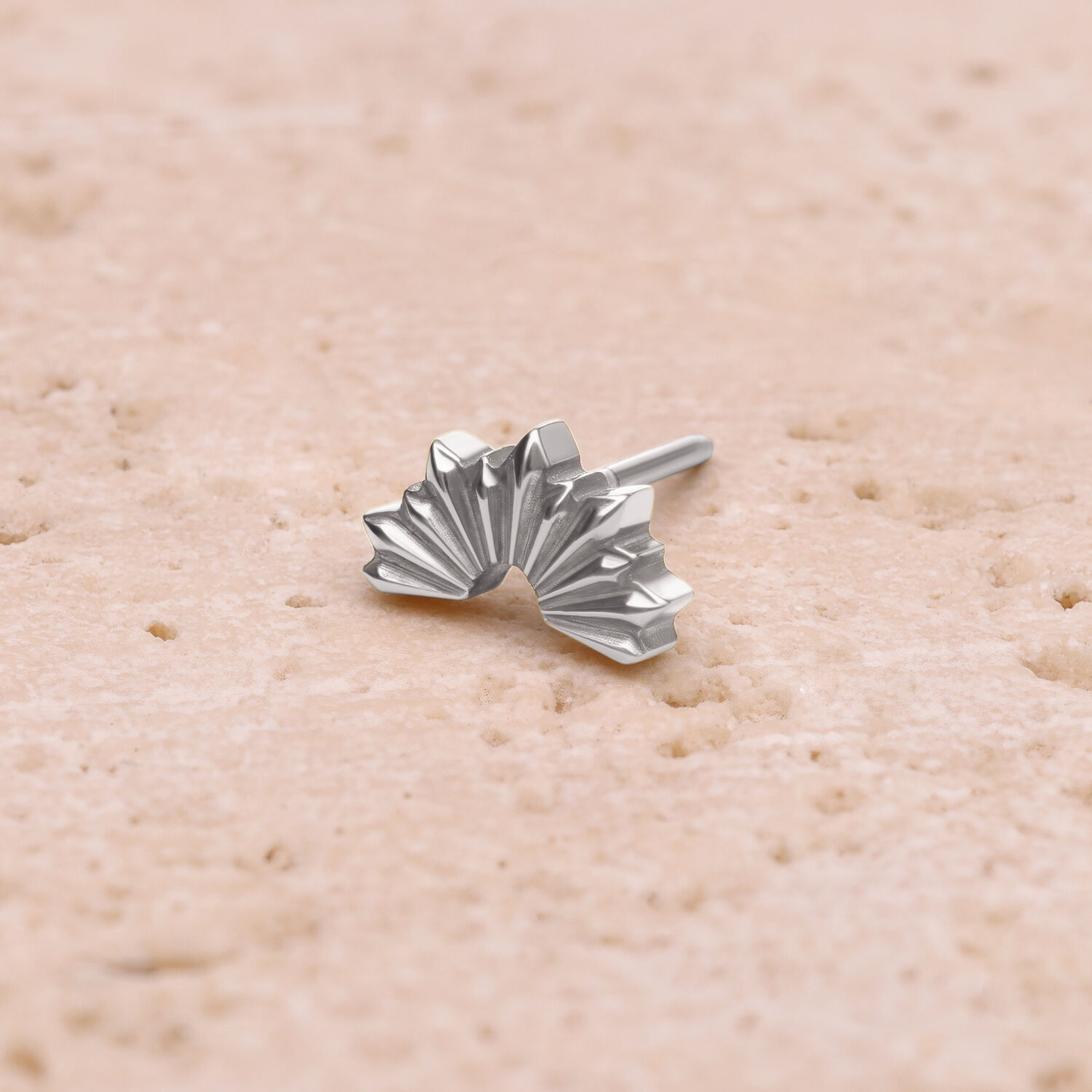 Embout rayons de soleil plié en argent sur fond sable
