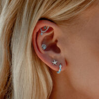 Piercing d'oreille coquillage en cristal turquoise Oreille avec plusieurs piercings, y compris un embout coquillage en cristal turquoise en or blanc.