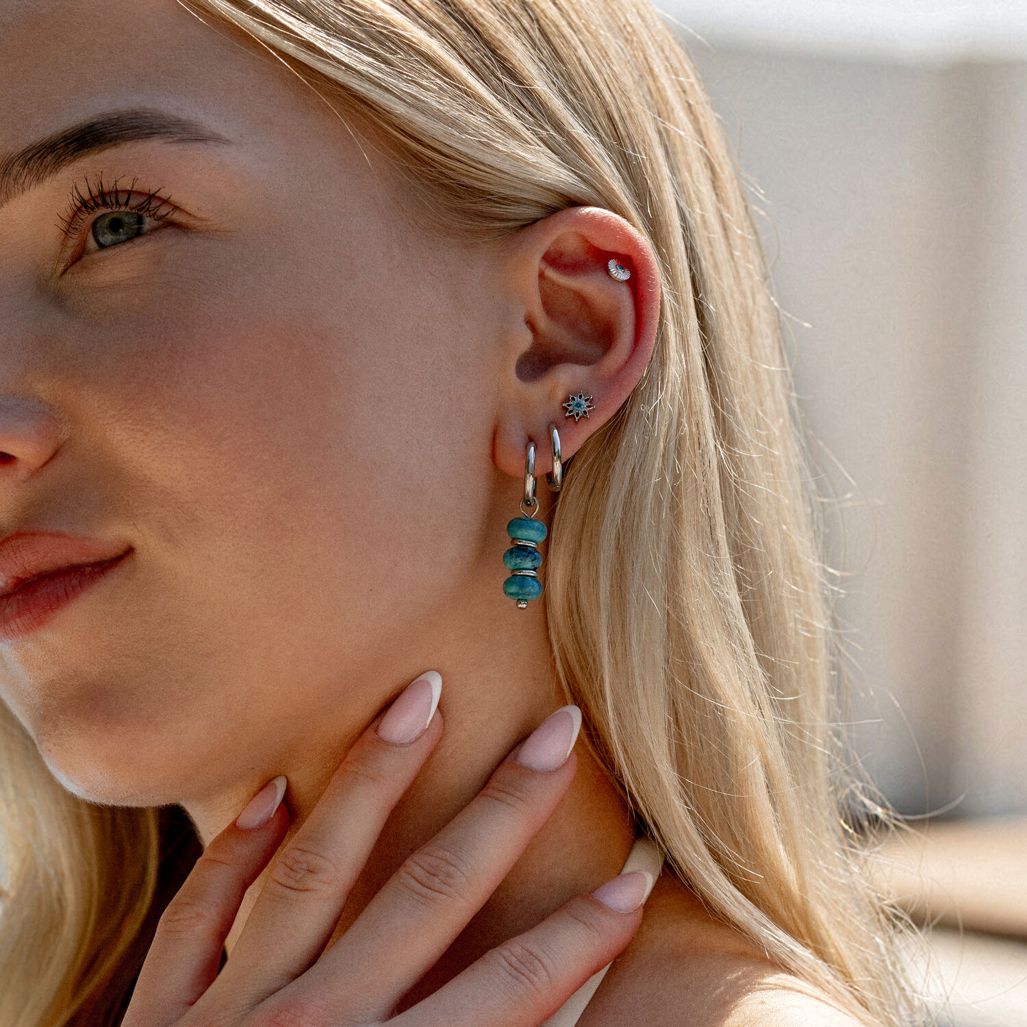 Embouts d'oreille en cristal turquoise Femme avec embouts d'oreille en cristal turquoise et créoles en or blanc, gros plan
