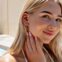 Double turquoise helix auroreille Gros plan d'une femme avec un double turquoise helix en titane à l'oreille, au soleil