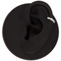 Modèle d'oreille noir avec un clicker de piercing ondulé en titane et cristaux clairs, sur fond noir